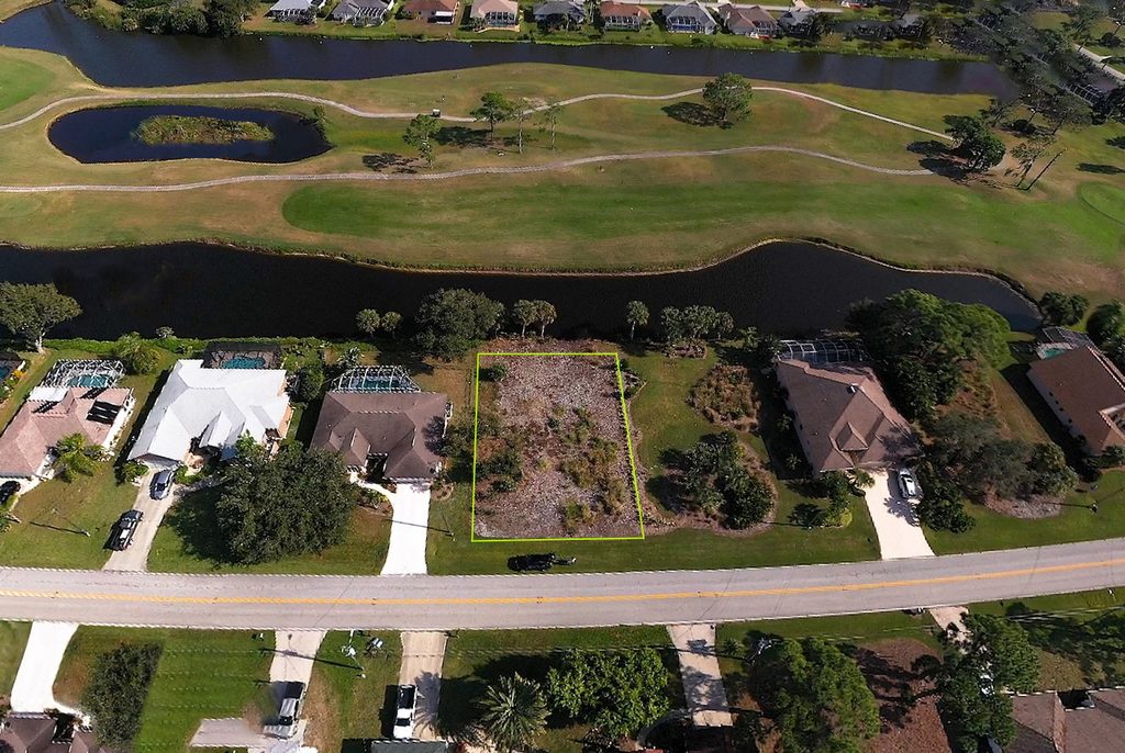 Blick auf eine Baulücke eine Baugrundstücks im Rotonda Circle, dass direkt  mit dem angrenzenden Frischwasserkanal an einem Golfplatz grenzt.