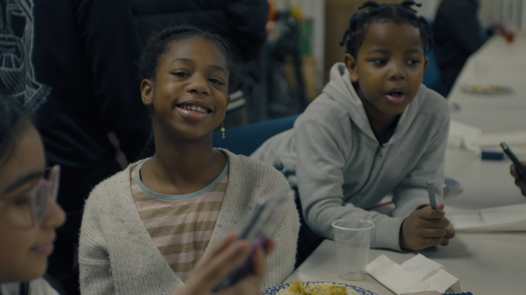 Two children smiling while sitting at a table