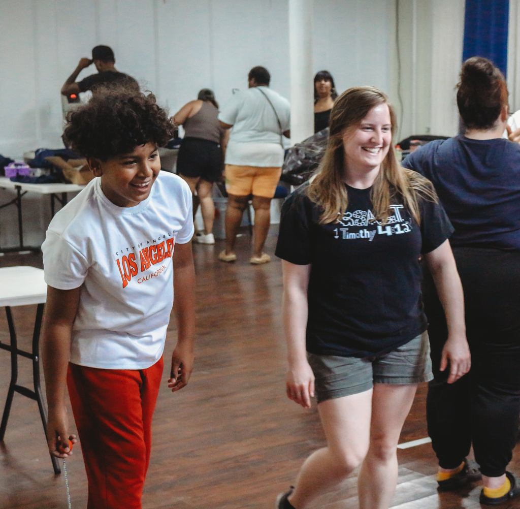 Volunteer and student playing game tossing a ball at a target