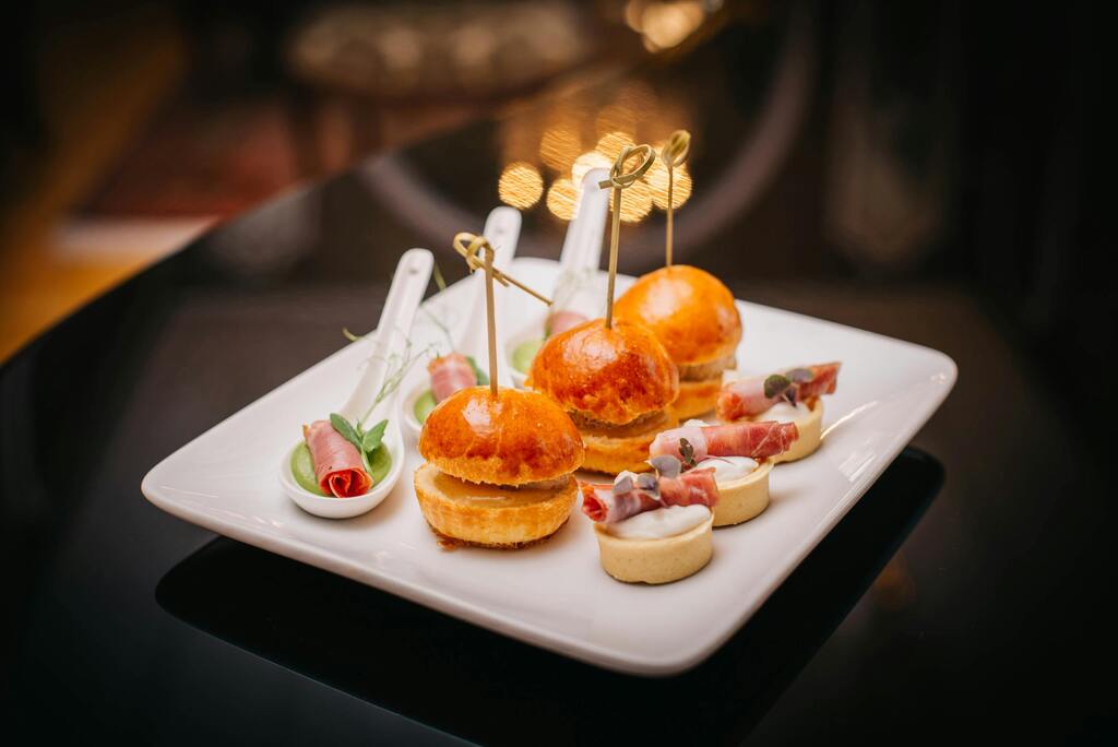 Fingerfood Catering Frankfurt – edle Mini-Burger, Canapés und Häppchen auf elegant angerichtetem Teller, ideal für Events und Firmenfeiern.