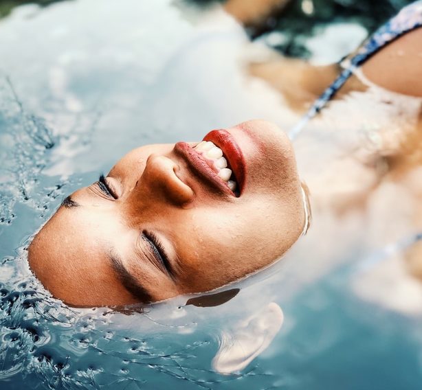 woman laying in spa bath with face above water