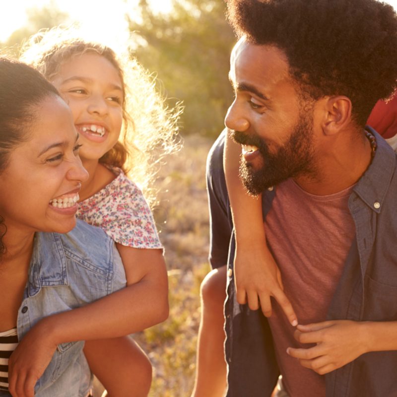 happy black man playing with daughters