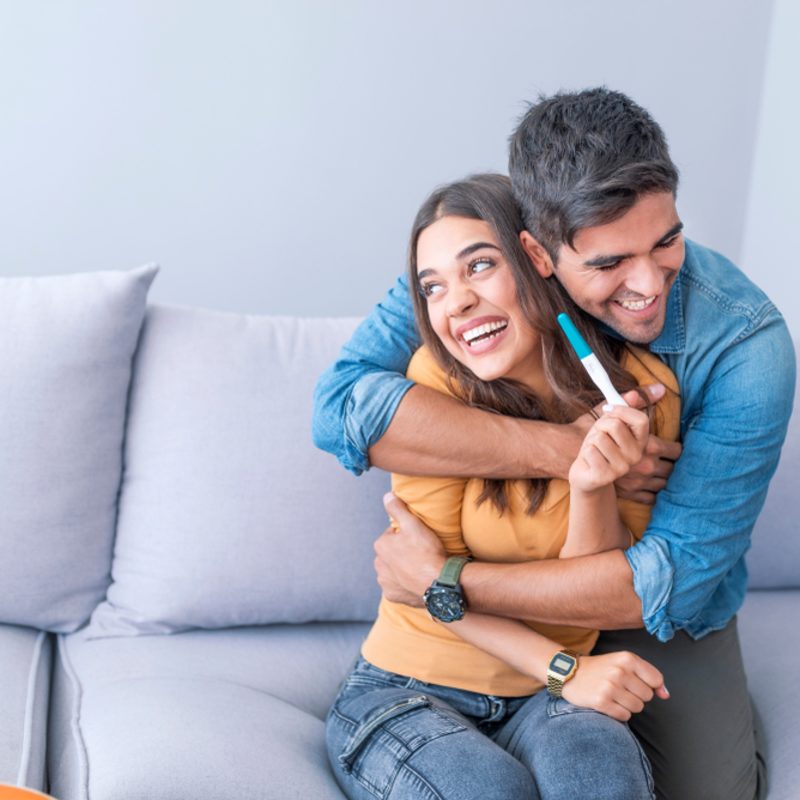young couple happy with positive pregnancy test